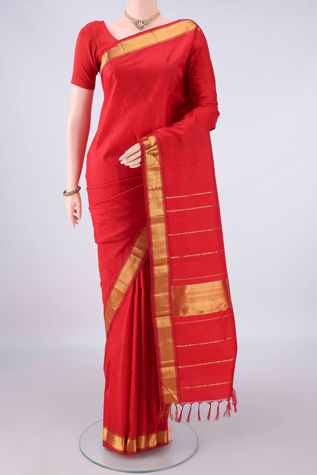 Pure Silk Red Kanjivaram Saree with Plain Body and Zari Border.  displayed on a mannequin