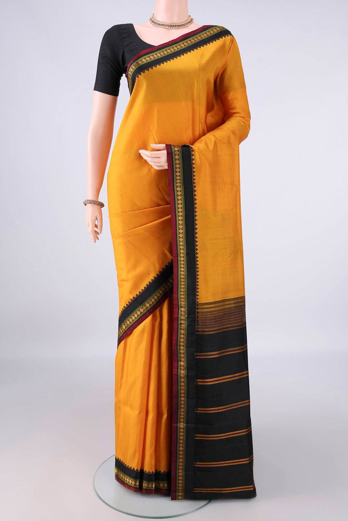 Pure Silk Mustard Kanjivaram Saree with Plain Body and Thread Border.  displayed on a mannequin