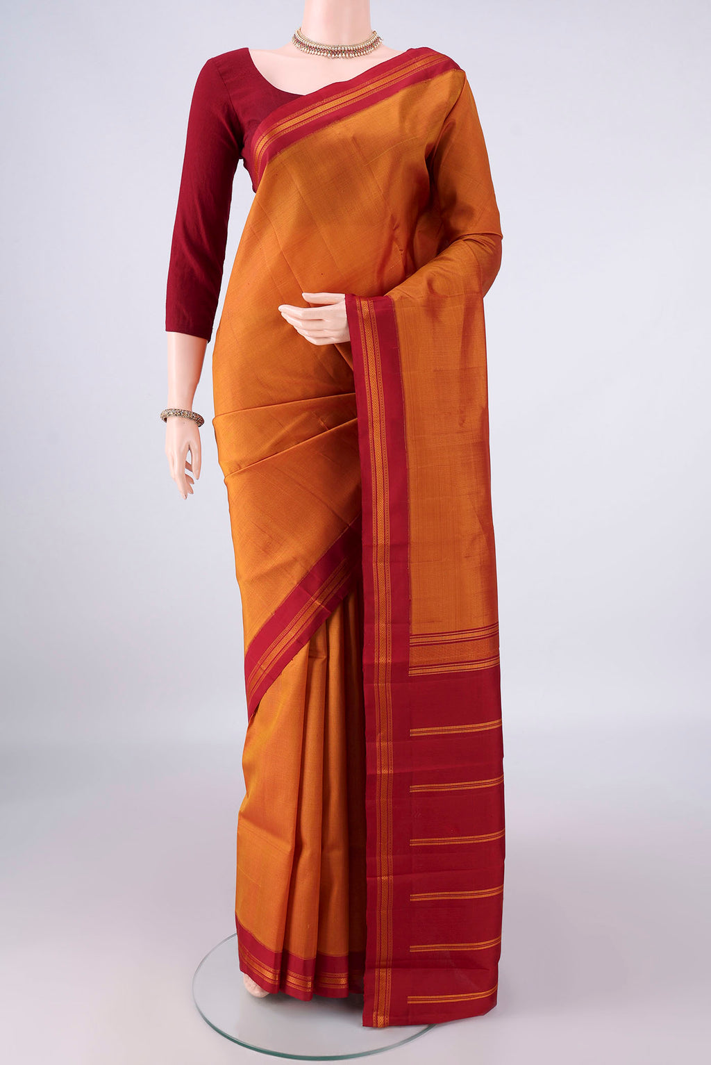 Pure Silk Mustard Kanjivaram Saree with Plain Body and Thread Border.  displayed on a mannequin