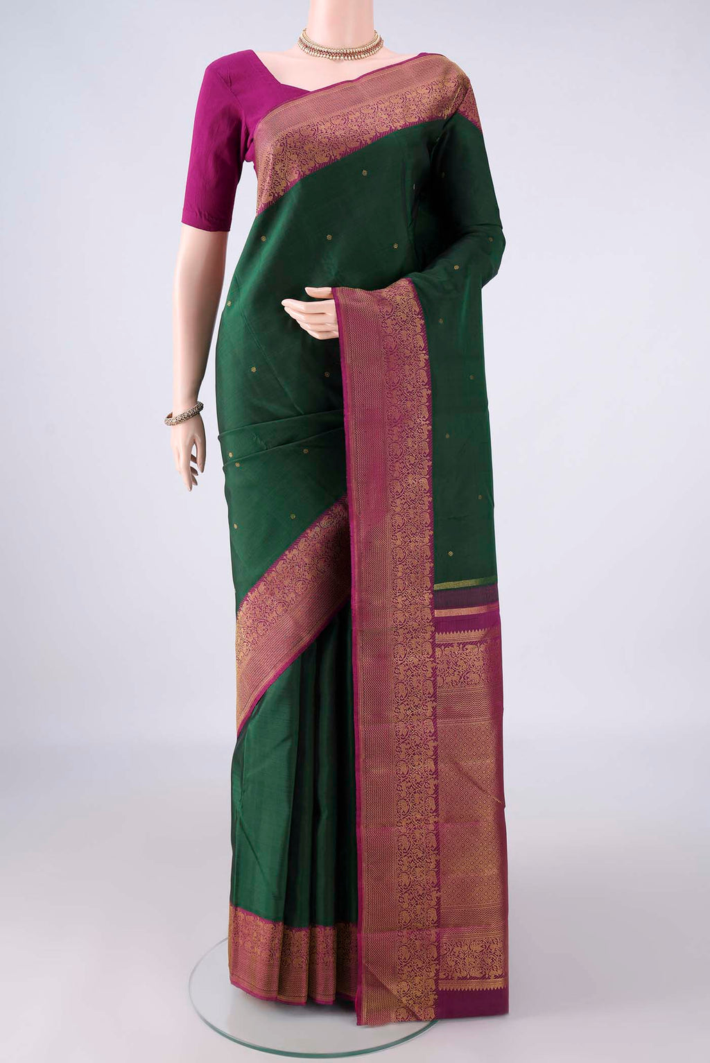 Pure Silk Bottle Green Kanjivaram Saree with Zari Butta on the body and Zari Border.  displayed on a mannequin