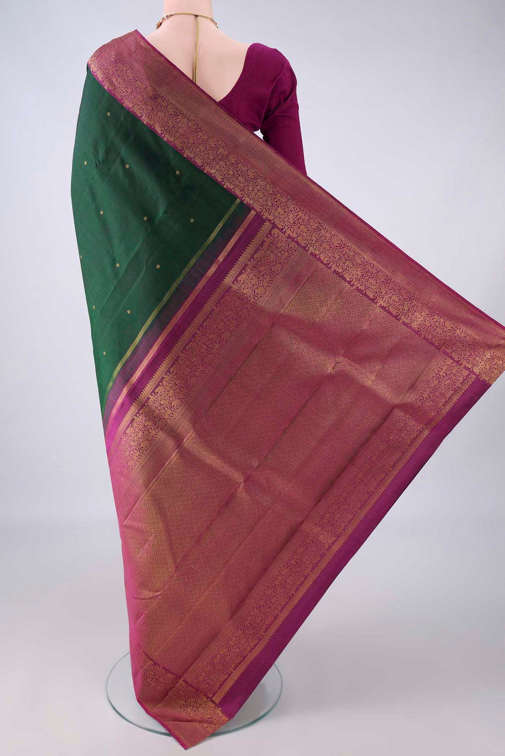 Flat view of Pure Silk Bottle Green Kanjivaram Saree with Zari Butta on the body and Zari Border. 