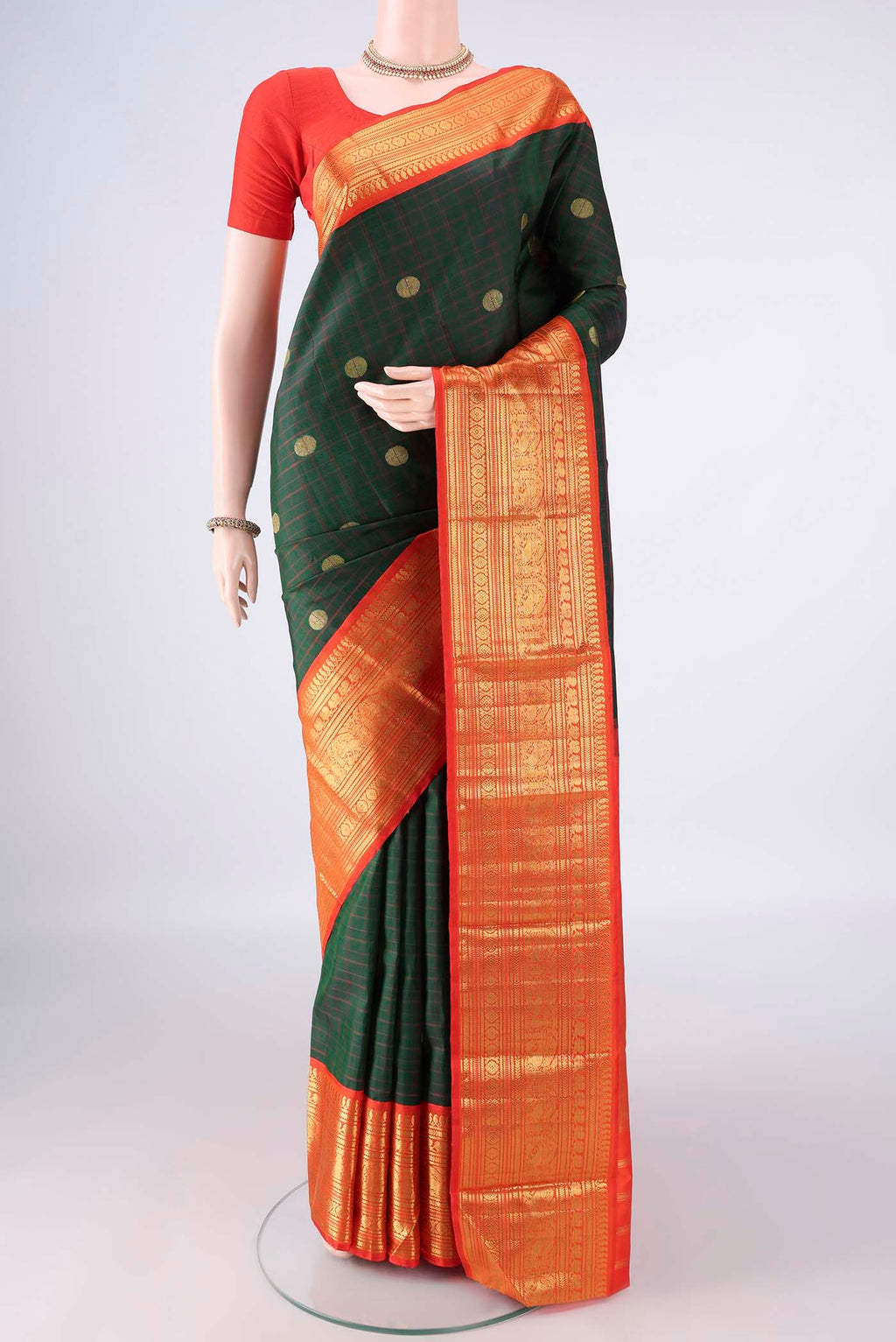 Pure Silk Bottle Green Kanchipuram Saree with Checked design on the body and Zari Border.  displayed on a mannequin
