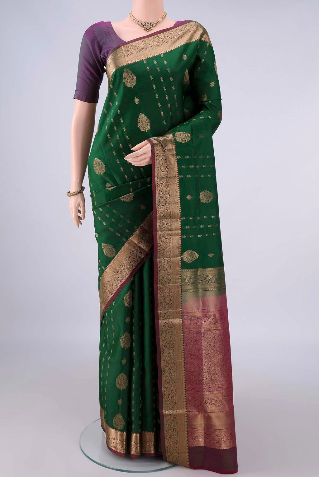 Pure Silk Bottle Green Soft Saree with Zari Butta on the body and Zari Border.  displayed on a mannequin