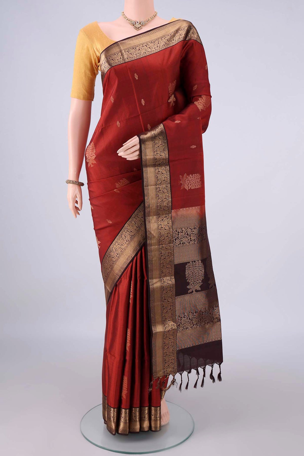 Pure Silk Rust Soft Saree with Zari Butta on the body and Zari Border.  displayed on a mannequin