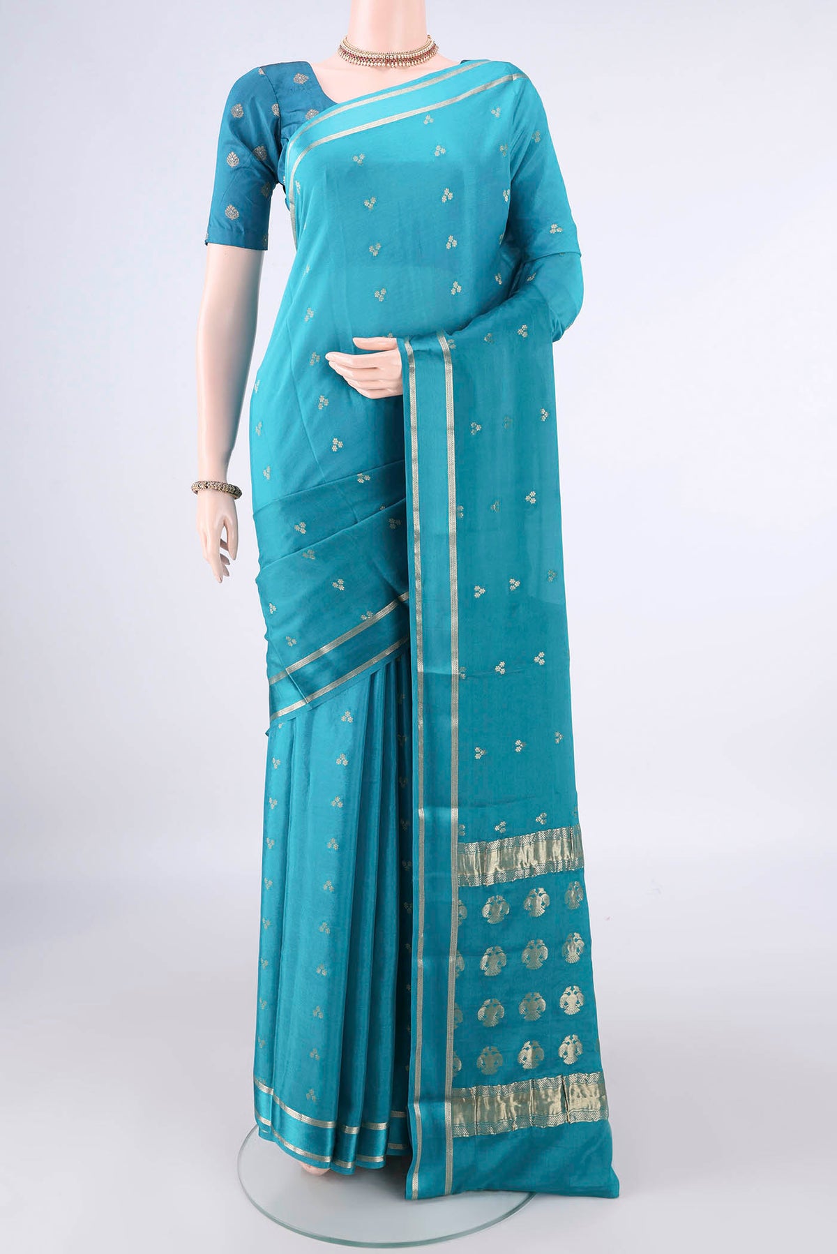 Turquoise Mysore Crepe Saree with Zari Butta on the body and Zari Border.  displayed on a mannequin