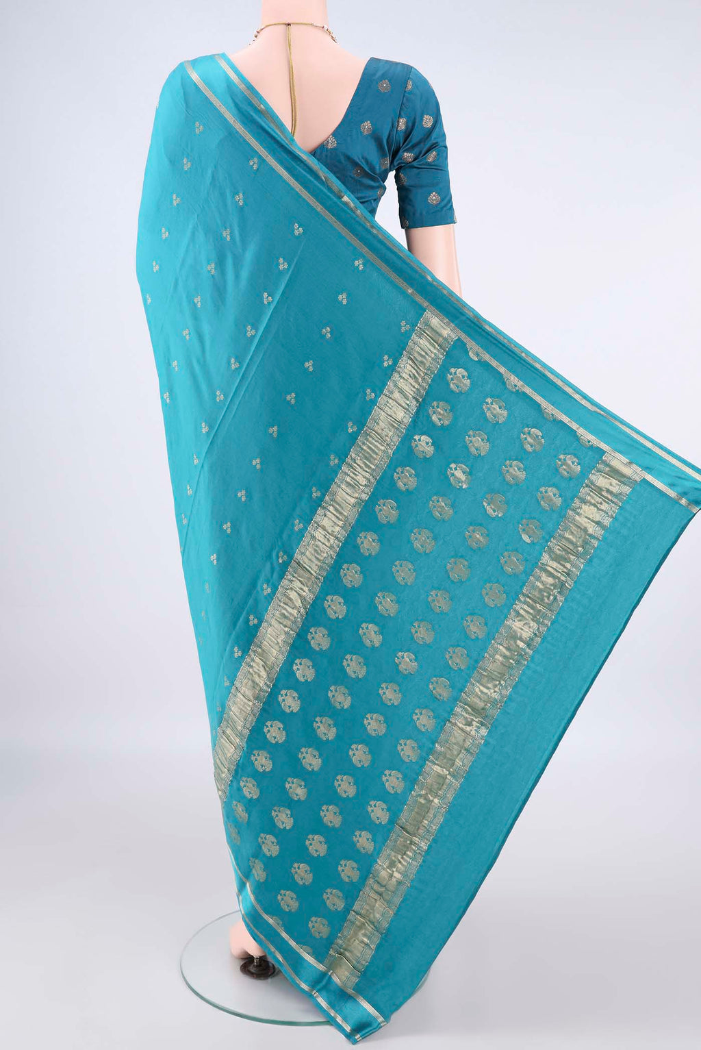 Flat view of Turquoise Mysore Crepe Saree with Zari Butta on the body and Zari Border. 