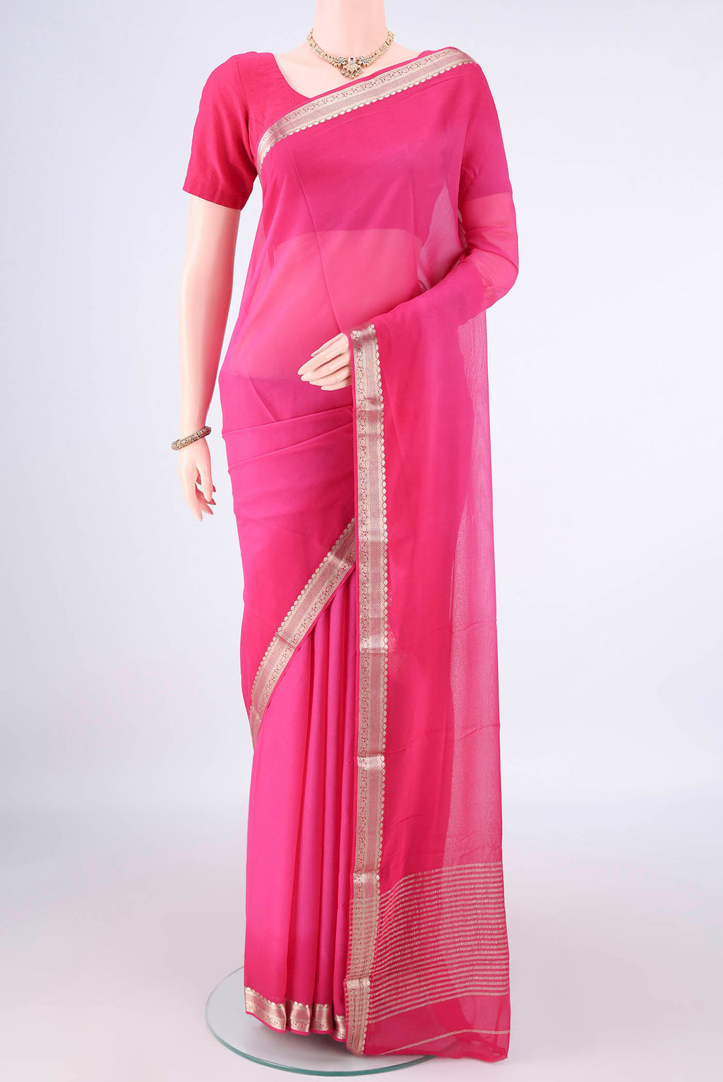 Rani Pink Mysore Georgette Saree with Plain Body and Zari Border.  displayed on a mannequin