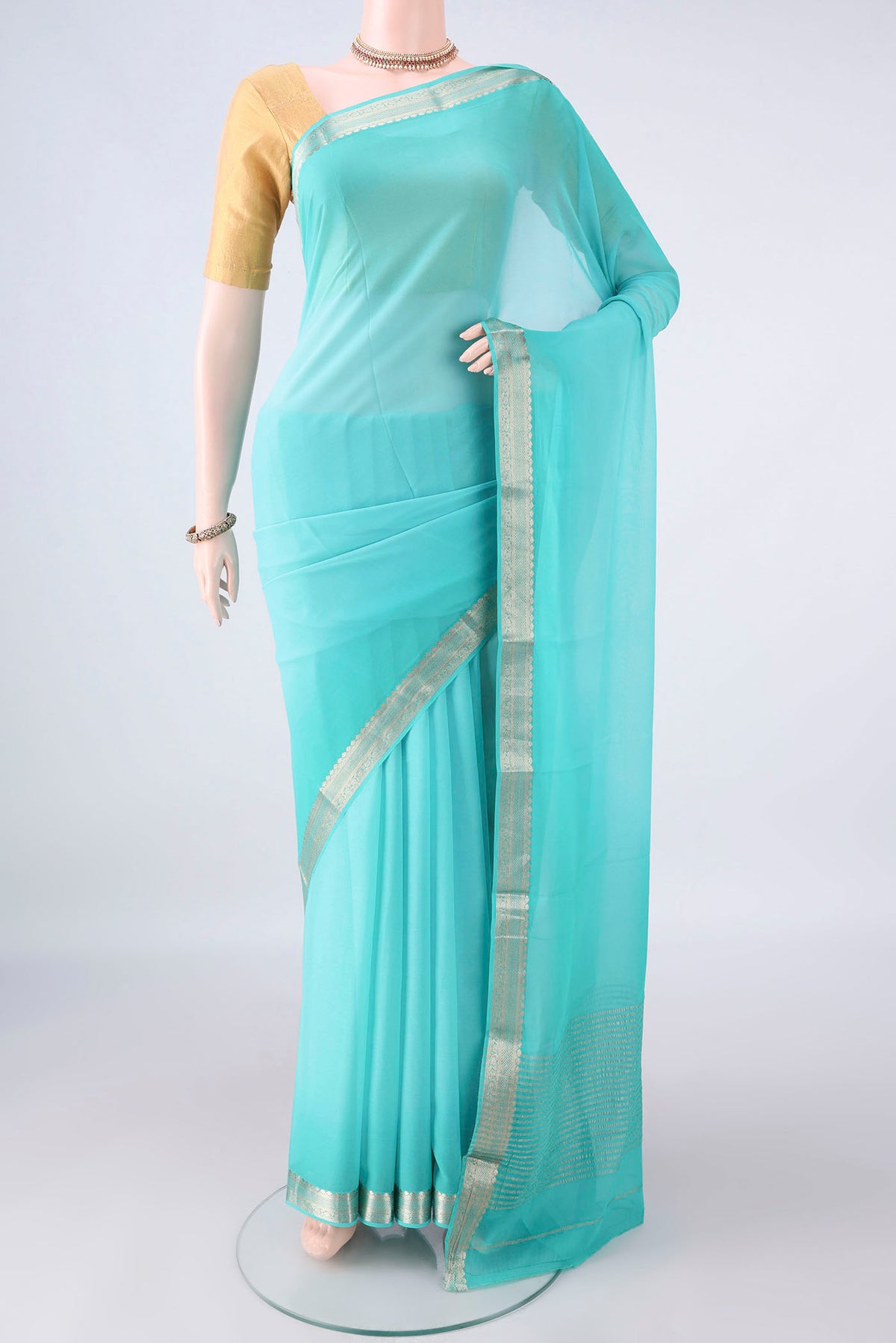 Turquoise Mysore Georgette Saree with Plain Body and Zari Border.  displayed on a mannequin