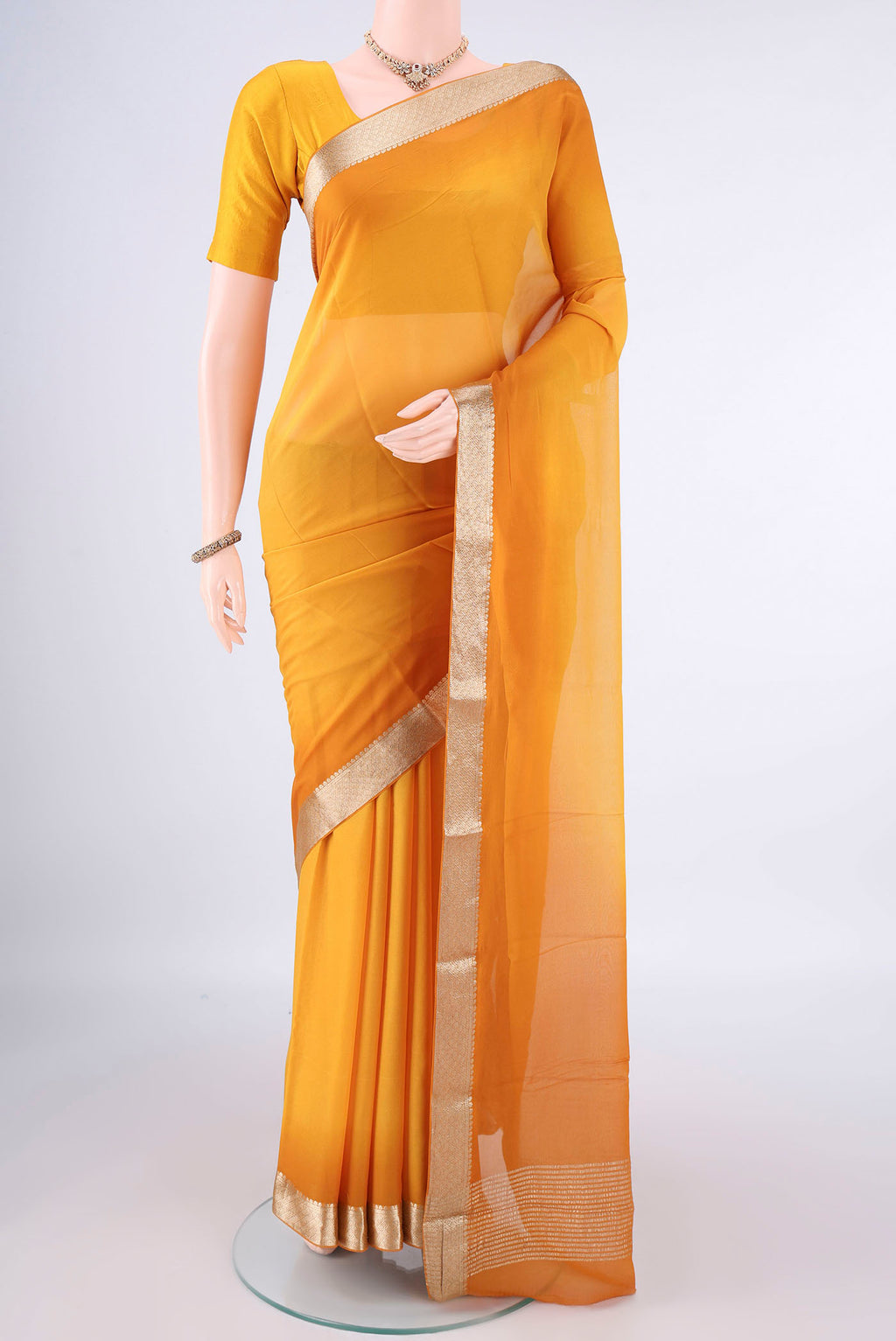 Yellow Mysore Georgette Saree with Plain Body and Zari Border.  displayed on a mannequin
