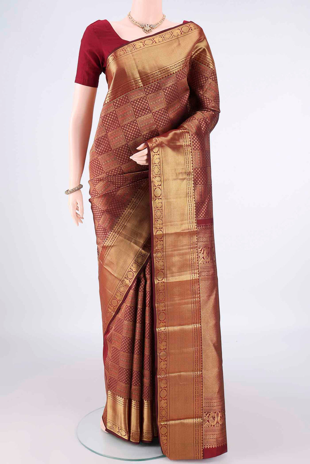 Pure Silk Maroon Kanchipuram Saree with Zari Brocade on the body and Zari Border.  displayed on a mannequin