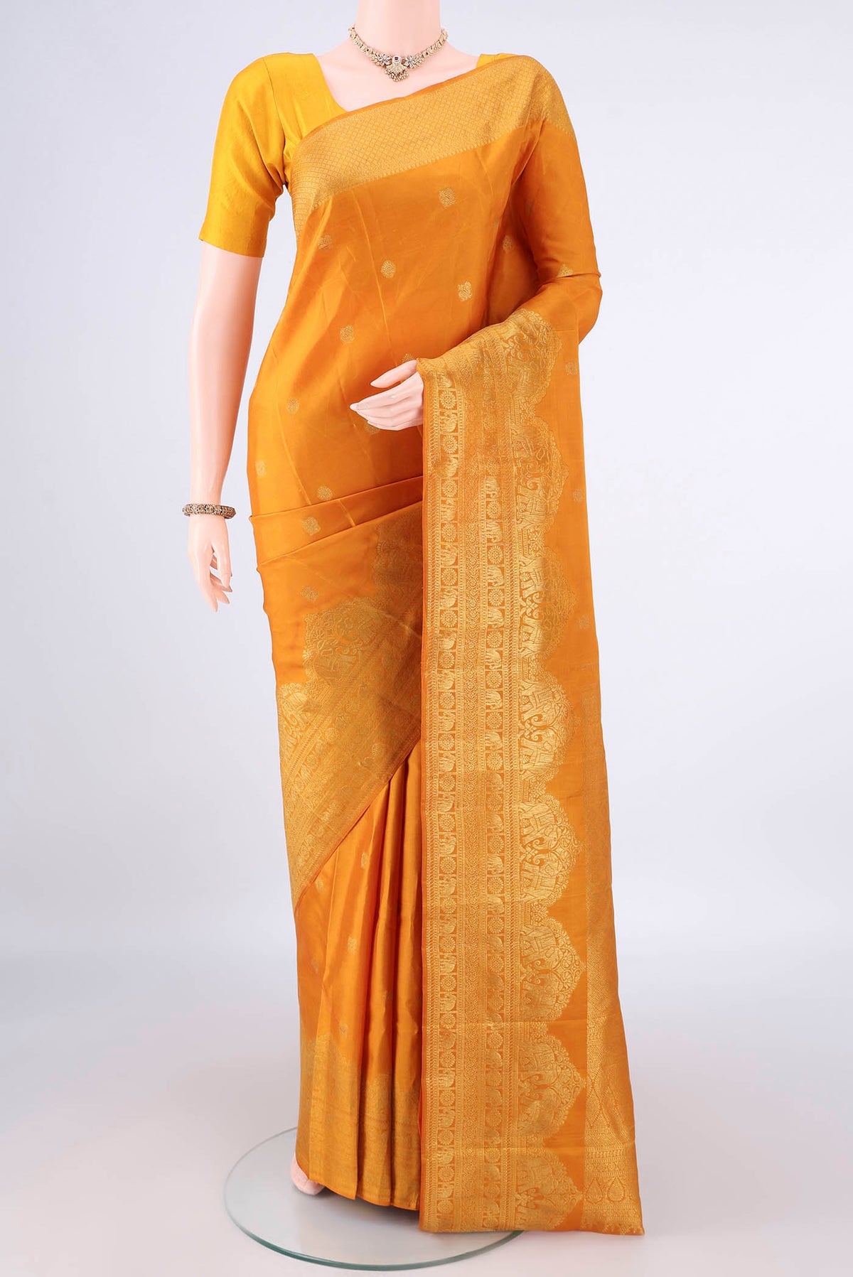 Pure Silk Mustard Kanchipuram Saree with Zari Butta on the body and Zari Border.  displayed on a mannequin