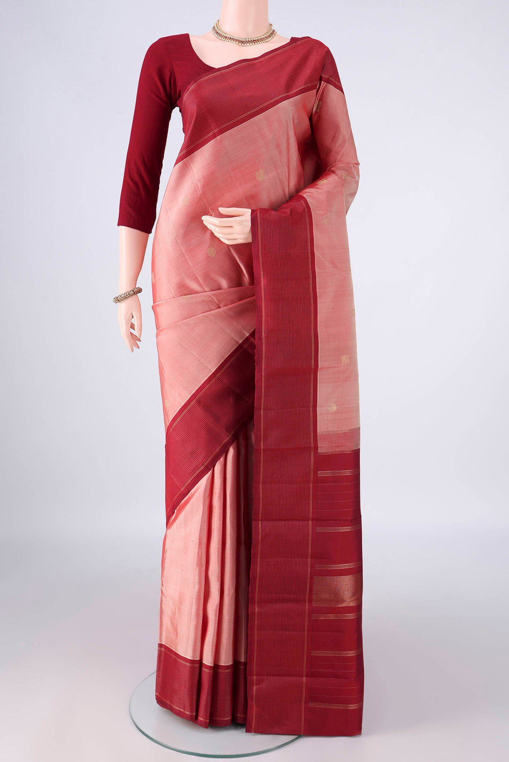 Pure Silk Pure Zari Peach Kanchipuram Saree with Zari Butta on the body and Plain Border.  displayed on a mannequin