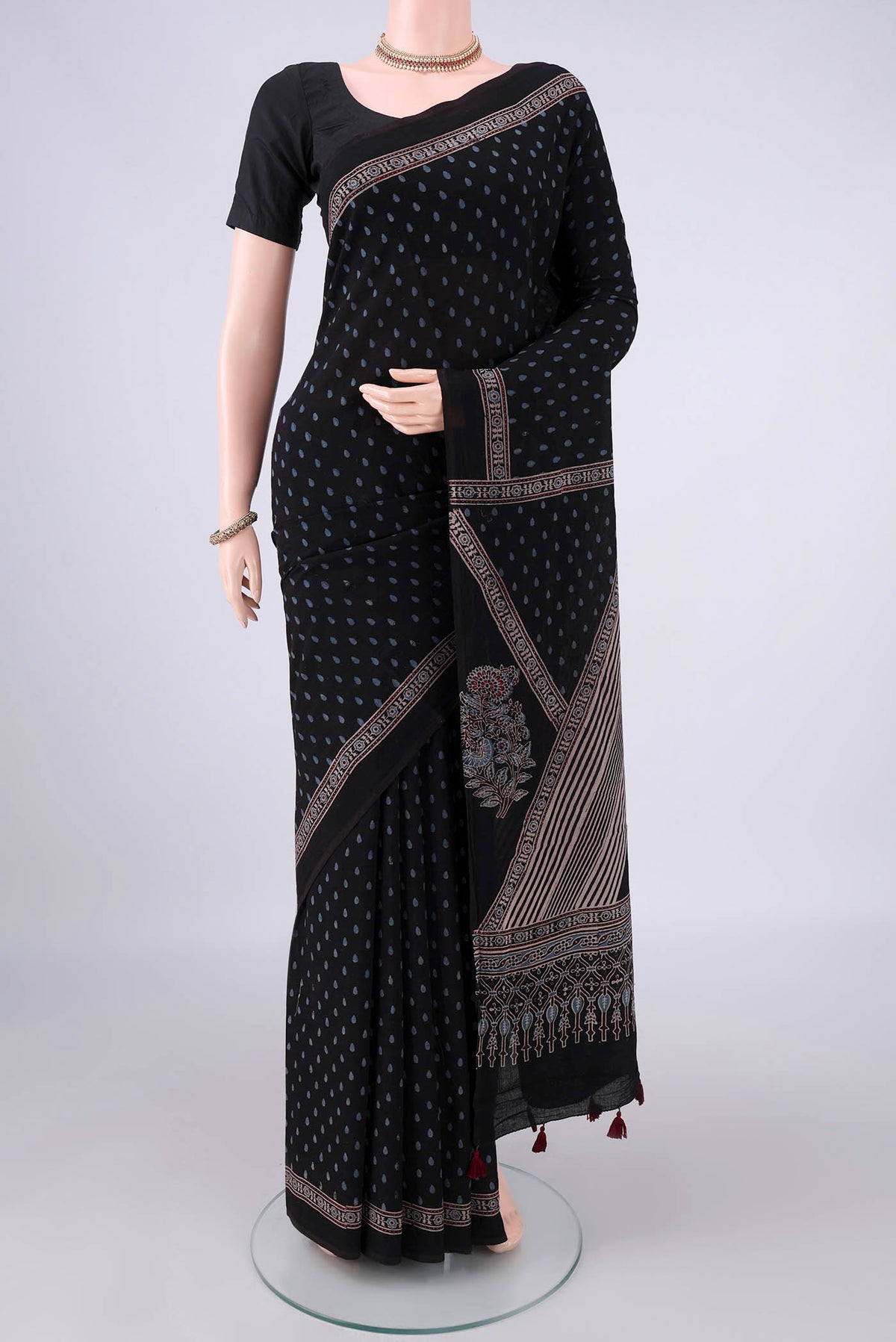 Black Cotton Saree with Ajrakh Print on the body and Plain Border.  displayed on a mannequin