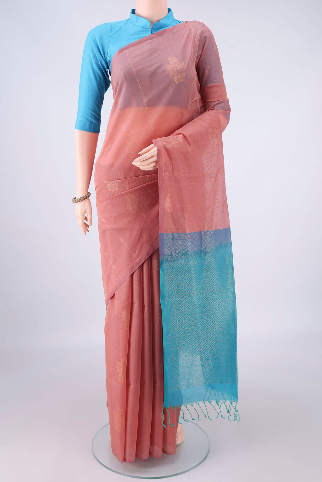 Peach Silk Cotton Saree with Zari Butta on the body and Without Border.  displayed on a mannequin