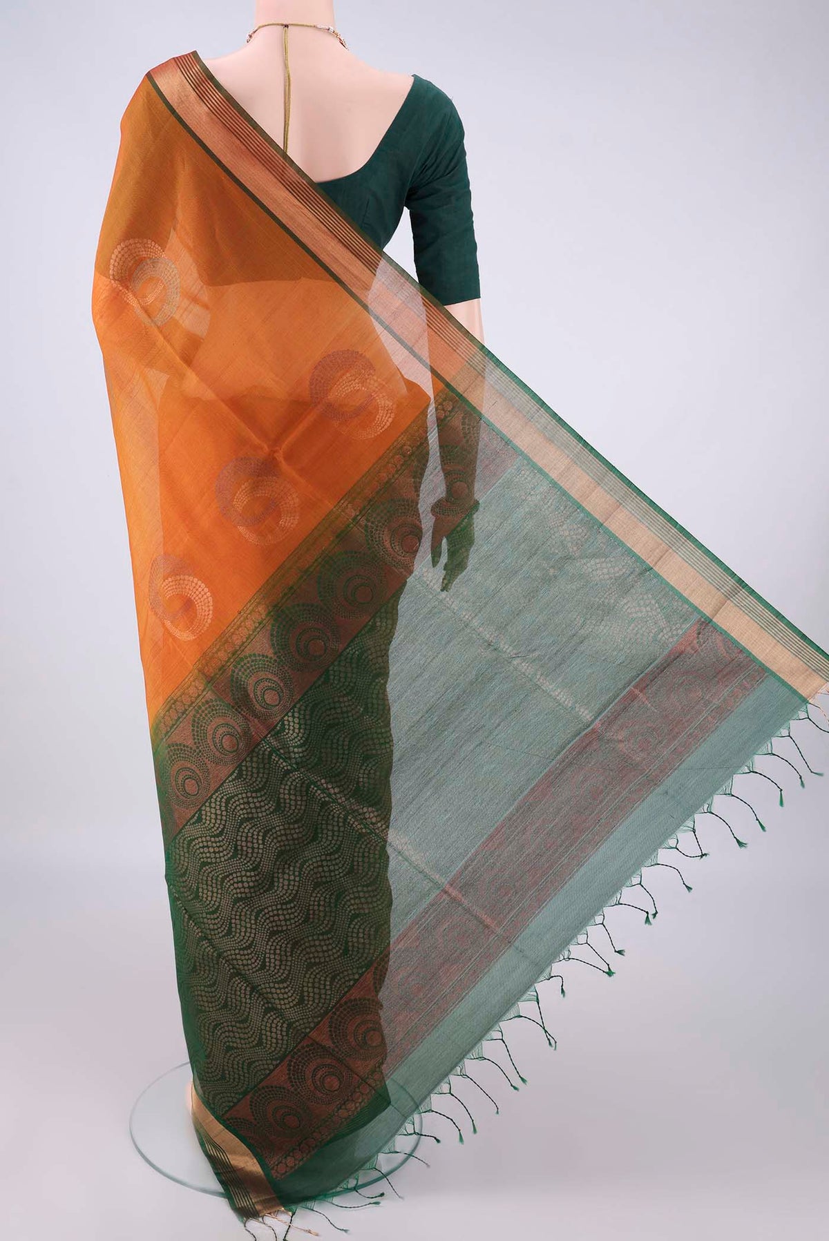 Flat view of Brick Orange Silk Cotton Saree with Zari And Thread Butta on the body and Zari Border. 