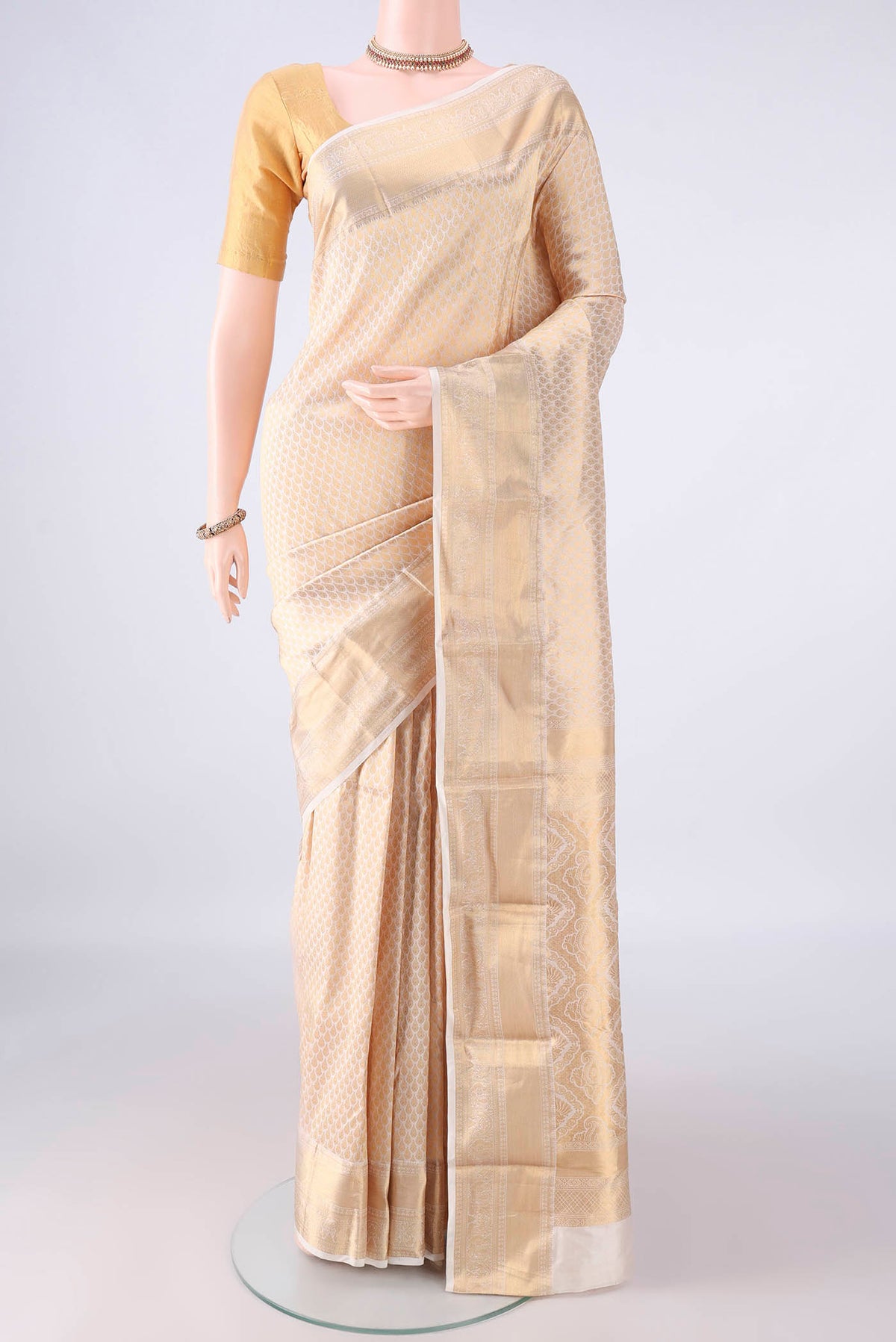 Pure Silk Off White Kanjivaram Saree with Zari Brocade on the body and Zari Border.  displayed on a mannequin