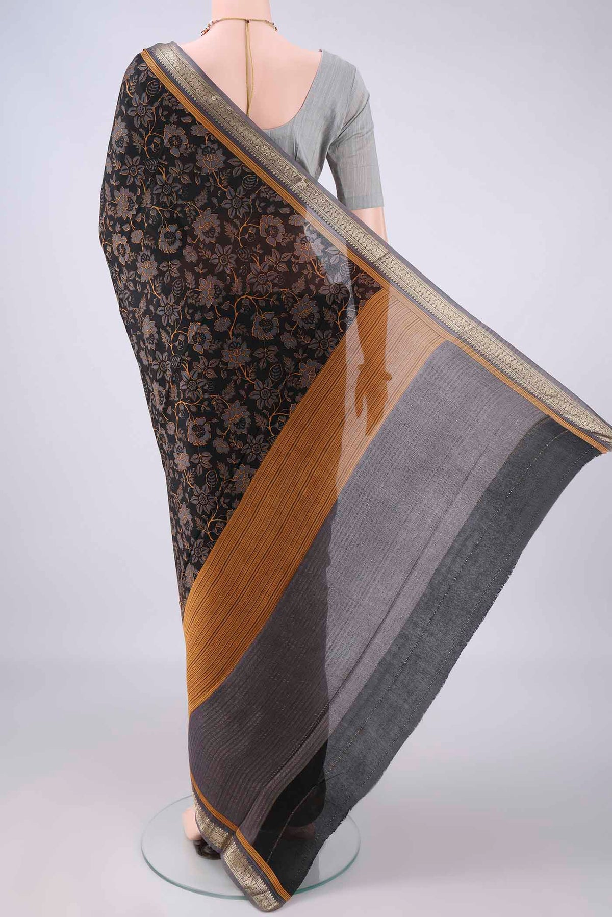 Flat view of Black Mysore Crepe Saree with Printed design on the body and Zari Border. 