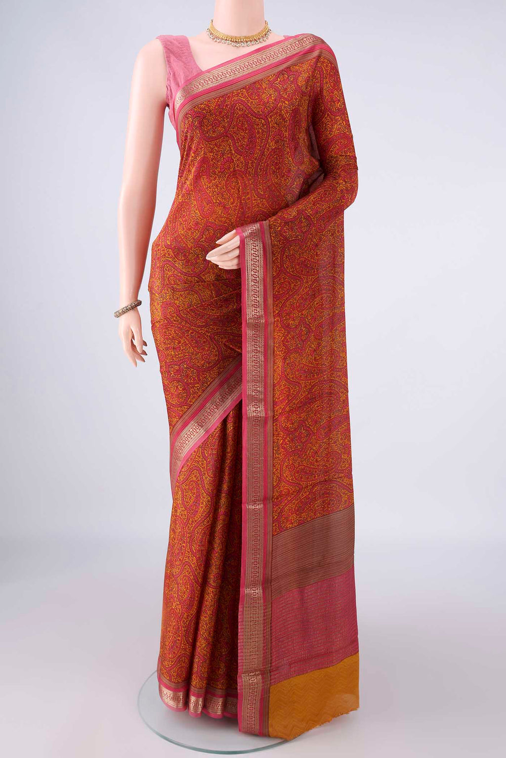 Mustard Mysore Crepe Saree with Printed design on the body and Zari Border.  displayed on a mannequin