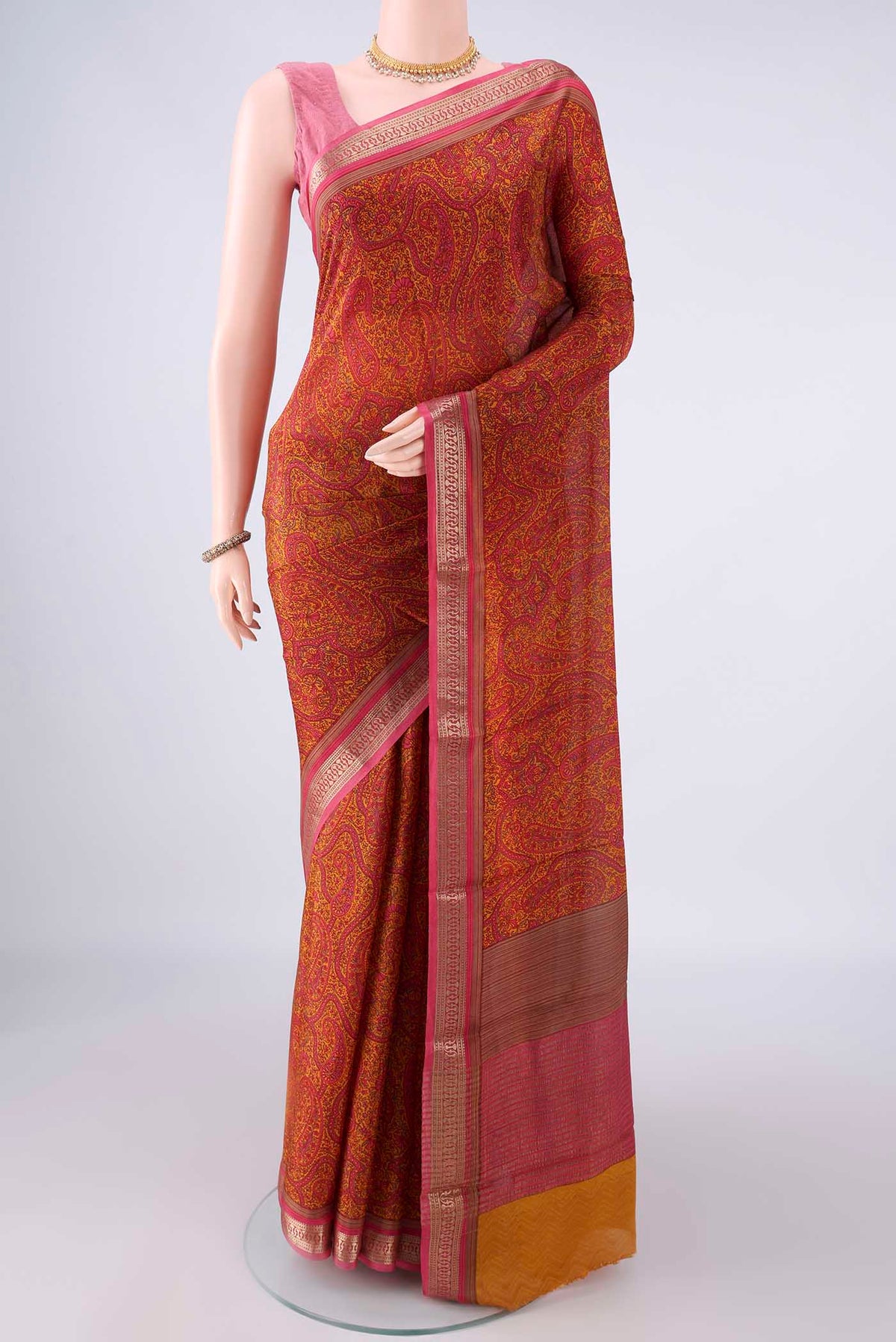 Mustard Mysore Crepe Saree with Printed design on the body and Zari Border.  displayed on a mannequin