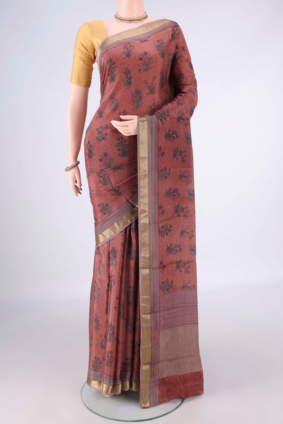 Peach Mysore Crepe Saree with Printed design on the body and Zari Border.  displayed on a mannequin