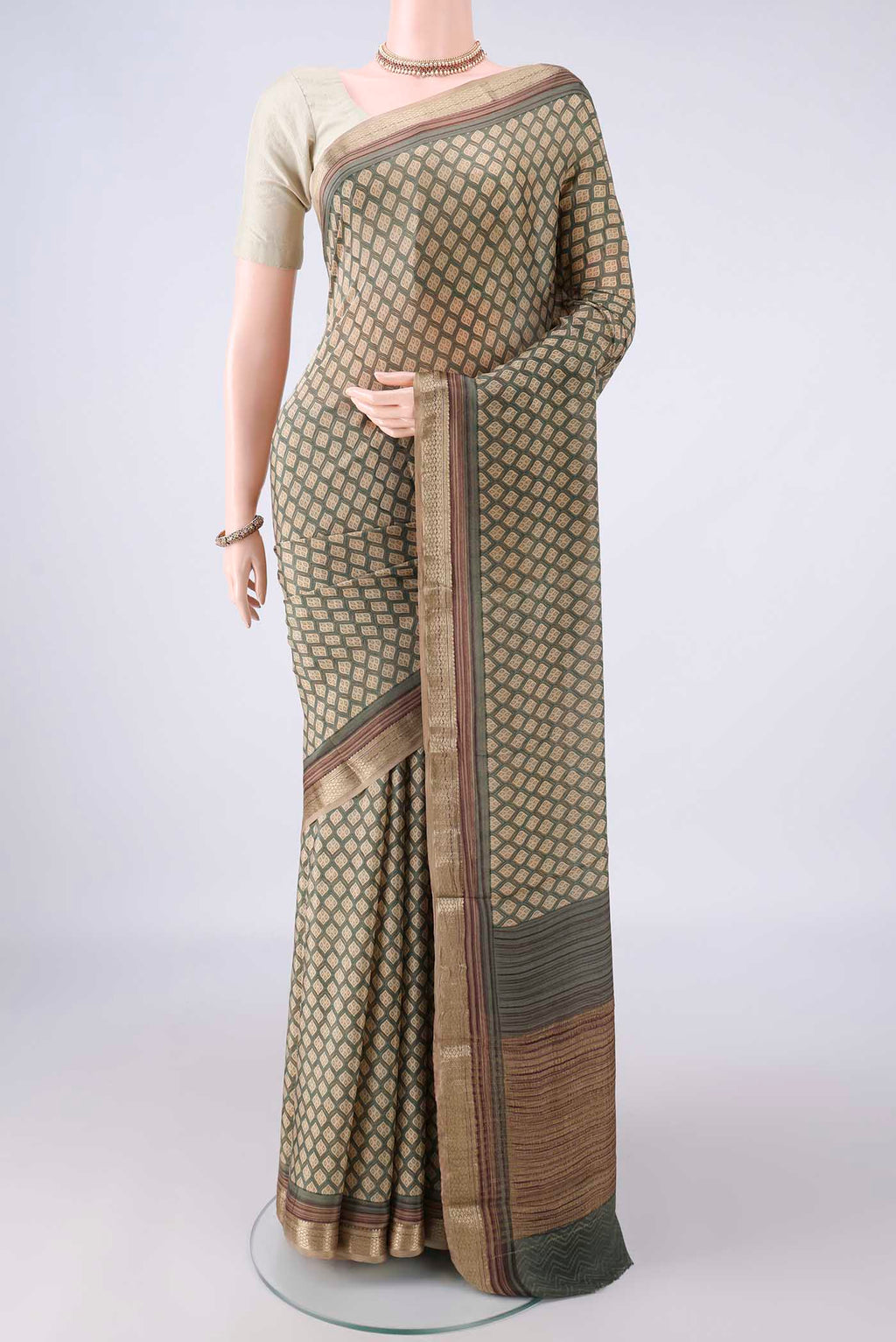 Beige Mysore Crepe Saree with Printed design on the body and Zari Border.  displayed on a mannequin
