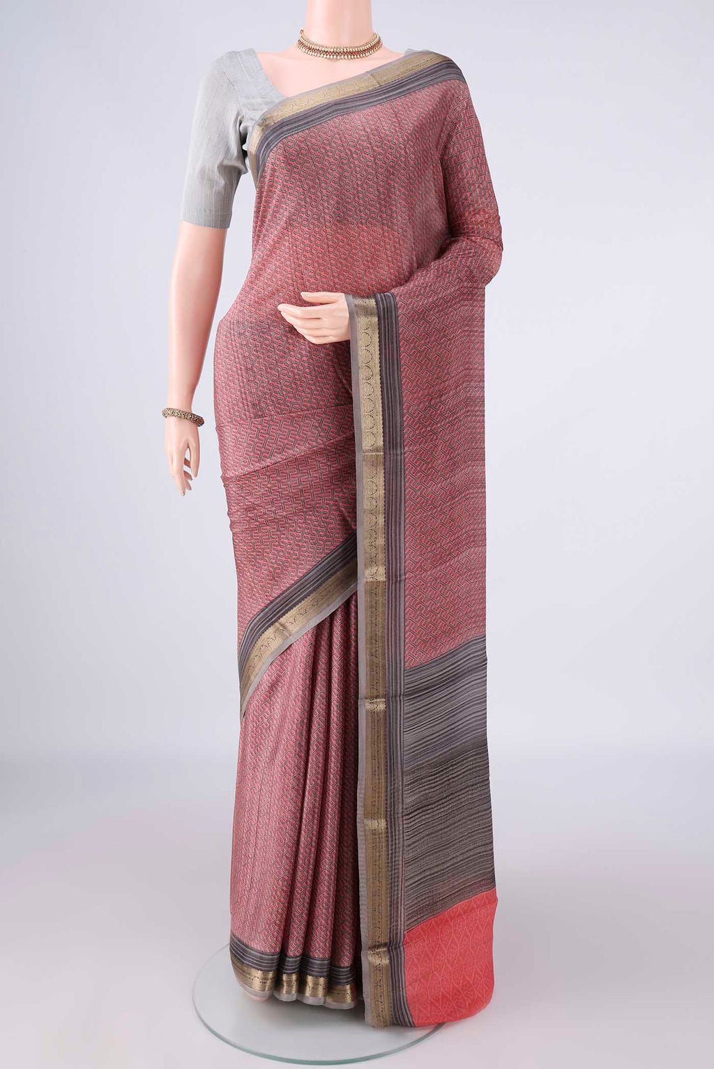 Peach Mysore Crepe Saree with Printed design on the body and Zari Border.  displayed on a mannequin