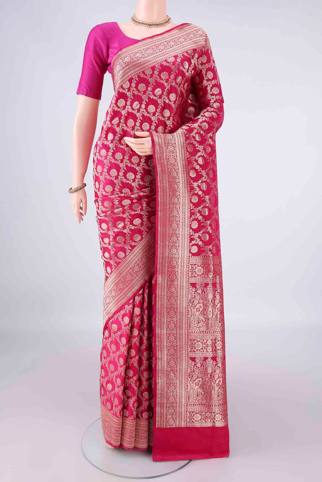 Pure Silk Rani Pink Banarasi Saree with Zari Brocade on the body and Zari Border.  displayed on a mannequin
