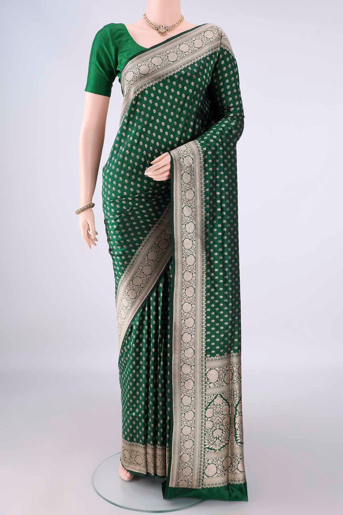 Pure Silk Bottle Green Banarasi Saree with Zari Butta on the body and Zari Border.  displayed on a mannequin