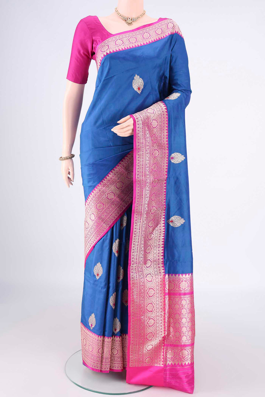 Pure Silk Royal Blue Banarasi Katan Saree with Zari And Thread Butta on the body and Zari Border.  displayed on a mannequin
