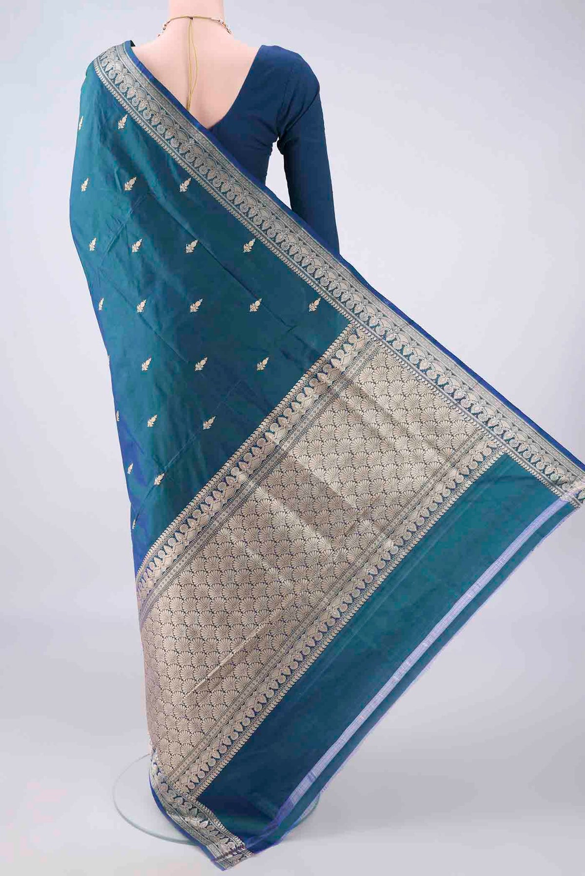 Flat view of Pure Silk Peacock Blue Banarasi Katan Saree with Thread Butta on the body and Thread Border. 