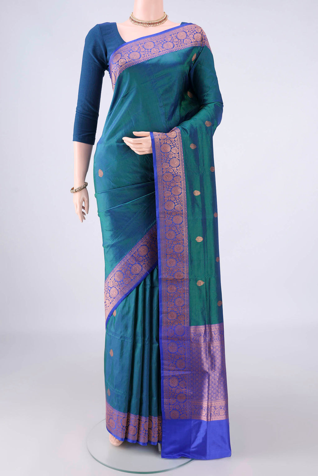 Pure Silk Peacock Blue Dual Tone Banarasi Katan Saree with Zari Butta on the body and Zari Border.  displayed on a mannequin