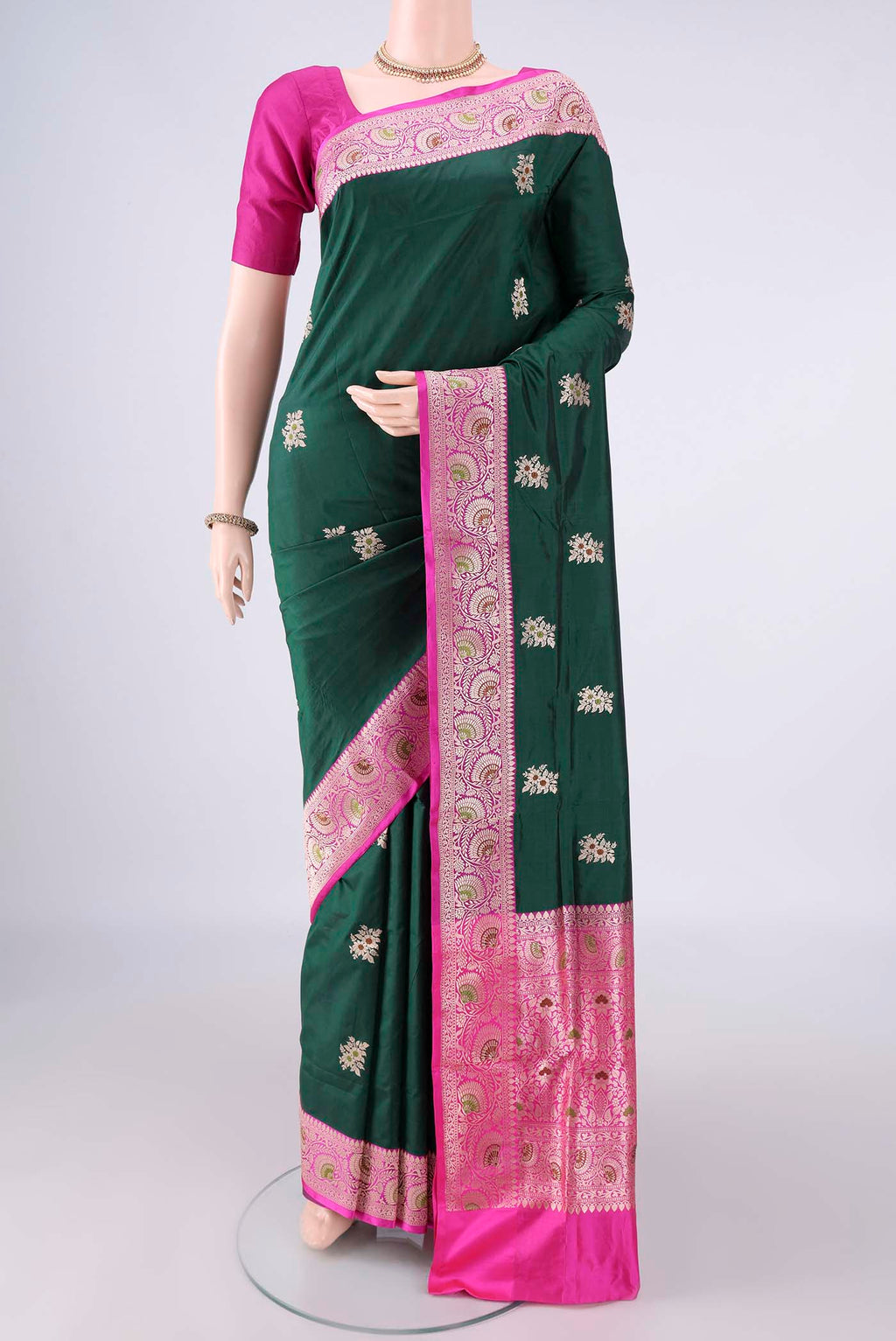 Pure Silk Bottle Green Banarasi Katan Saree with Zari And Thread Butta on the body and Zari Border.  displayed on a mannequin