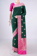 Pure Silk Bottle Green Banarasi Katan Saree with Zari And Thread Butta on the body and Zari Border.  displayed on a mannequin