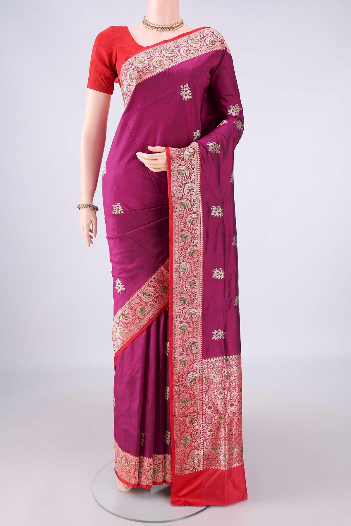 Pure Silk Magenta Banarasi Katan Saree with Zari And Thread Butta on the body and Zari Border.  displayed on a mannequin