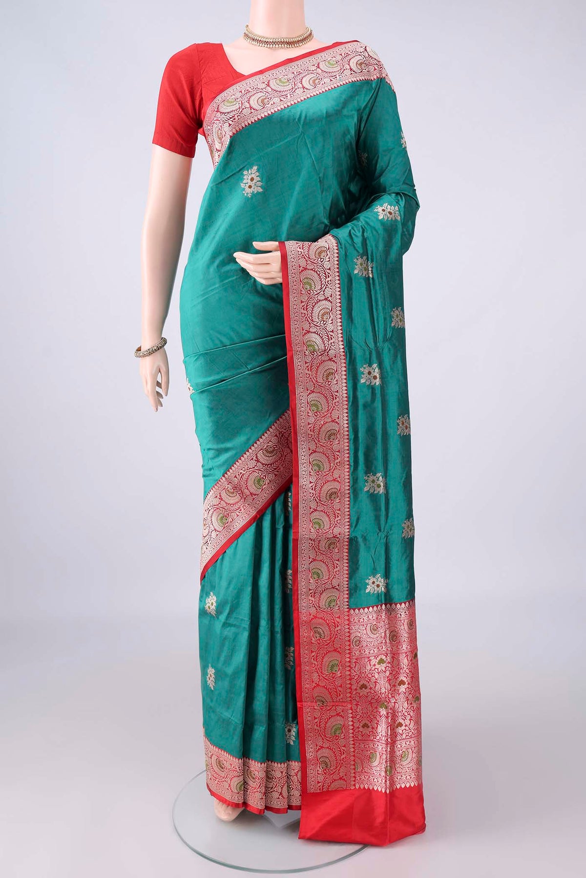 Pure Silk Sea Green Banarasi Katan Saree with Zari And Thread Butta on the body and Zari Border.  displayed on a mannequin