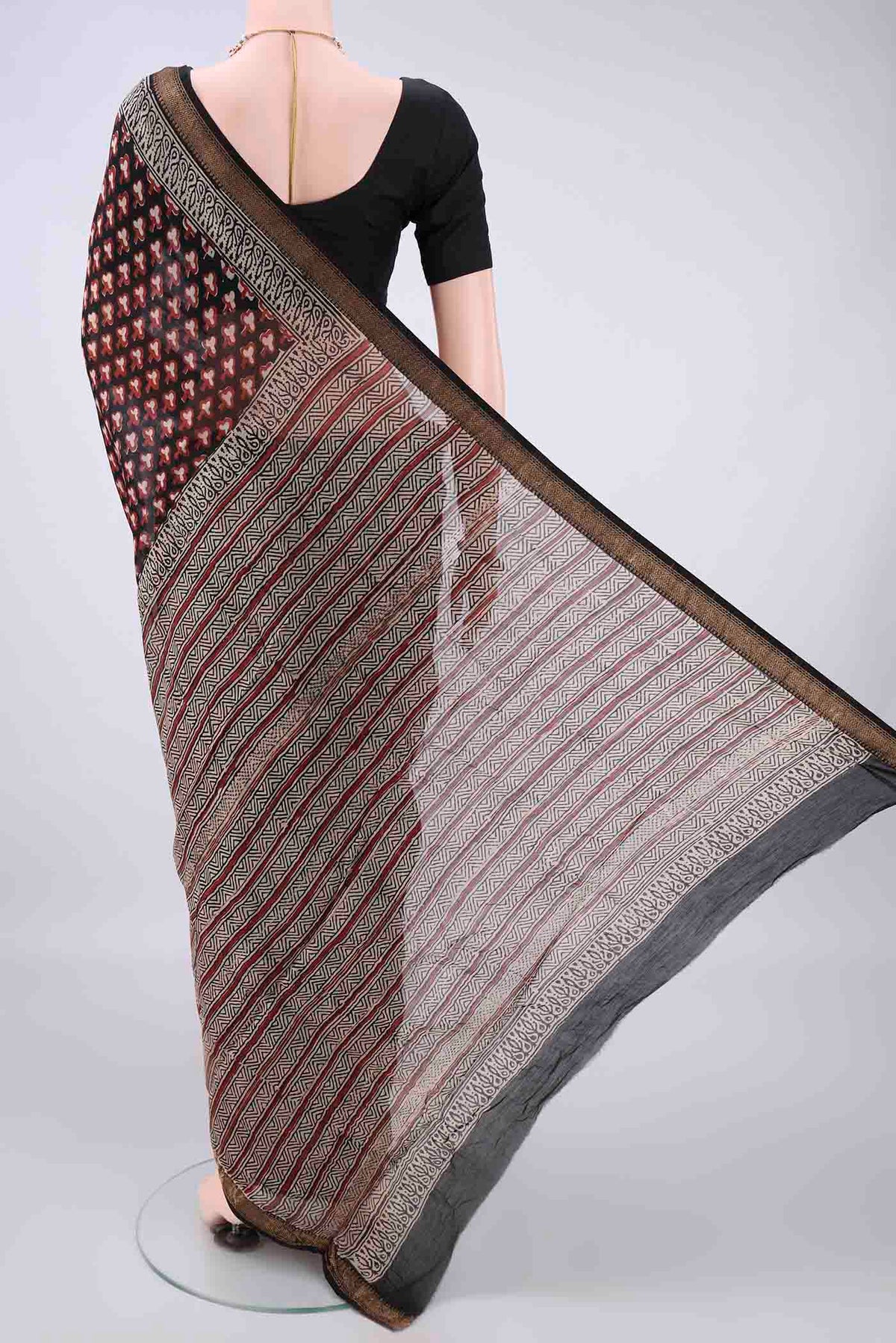 Flat view of Black Chanderi Cotton Saree with Batik Print on the body and Thin Zari Line. 