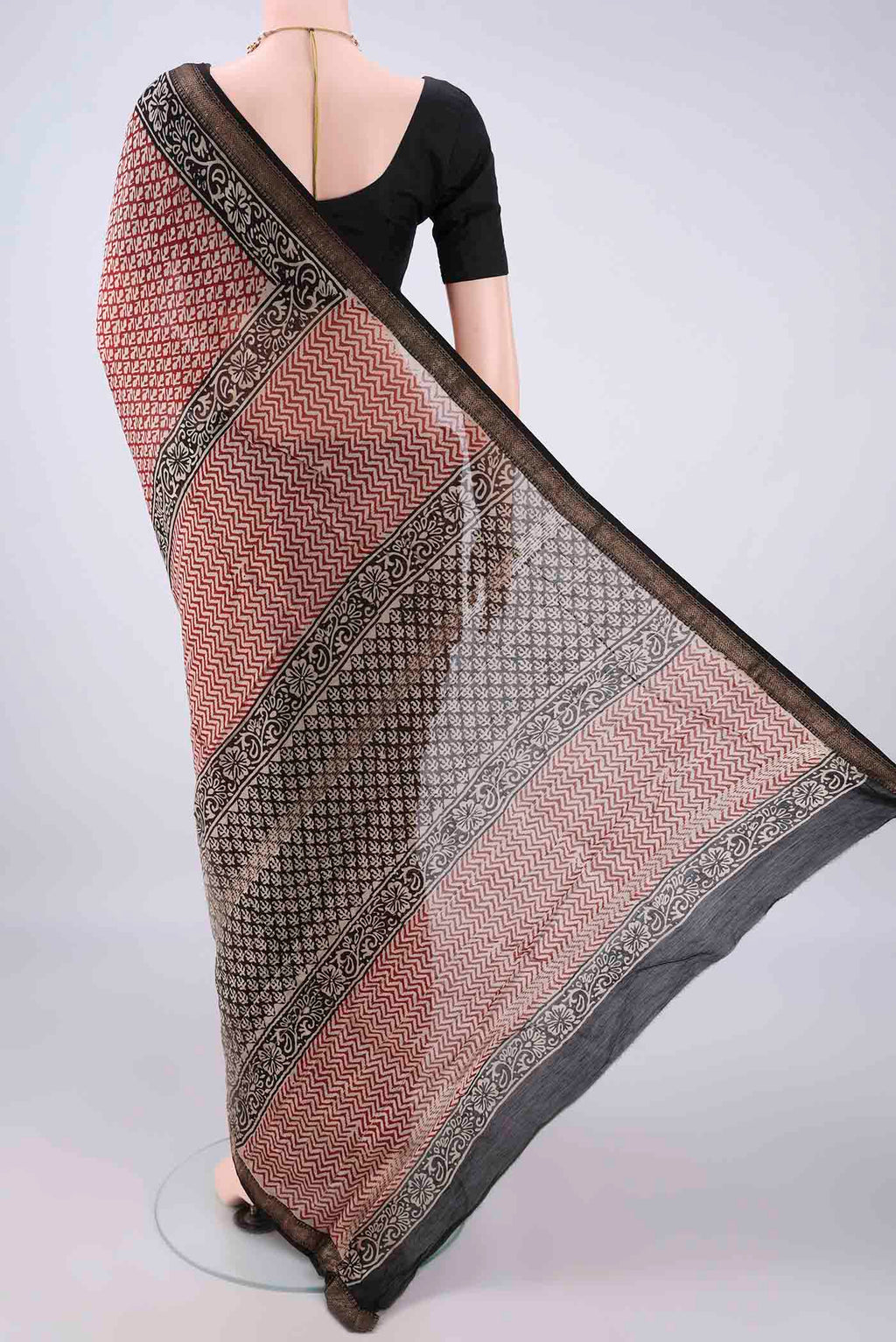Flat view of Maroon Maheshwari Cotton Saree with Batik Print on the body and Zari Border. 