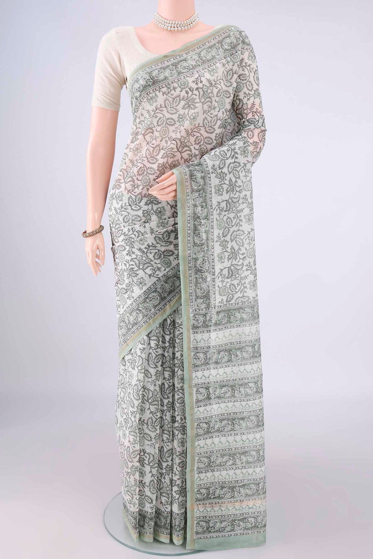 White Chanderi Cotton Saree with Printed design on the body and Thin Zari Line.  displayed on a mannequin