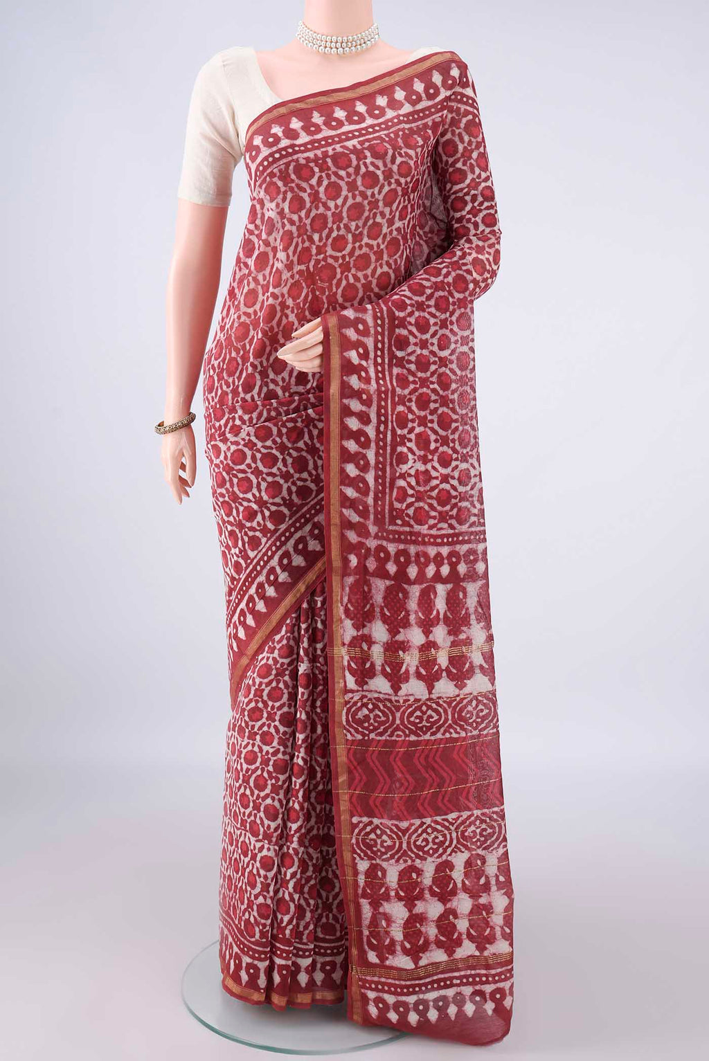 Coral Chanderi Cotton Saree with Batik Print on the body and Thin Zari Line.  displayed on a mannequin