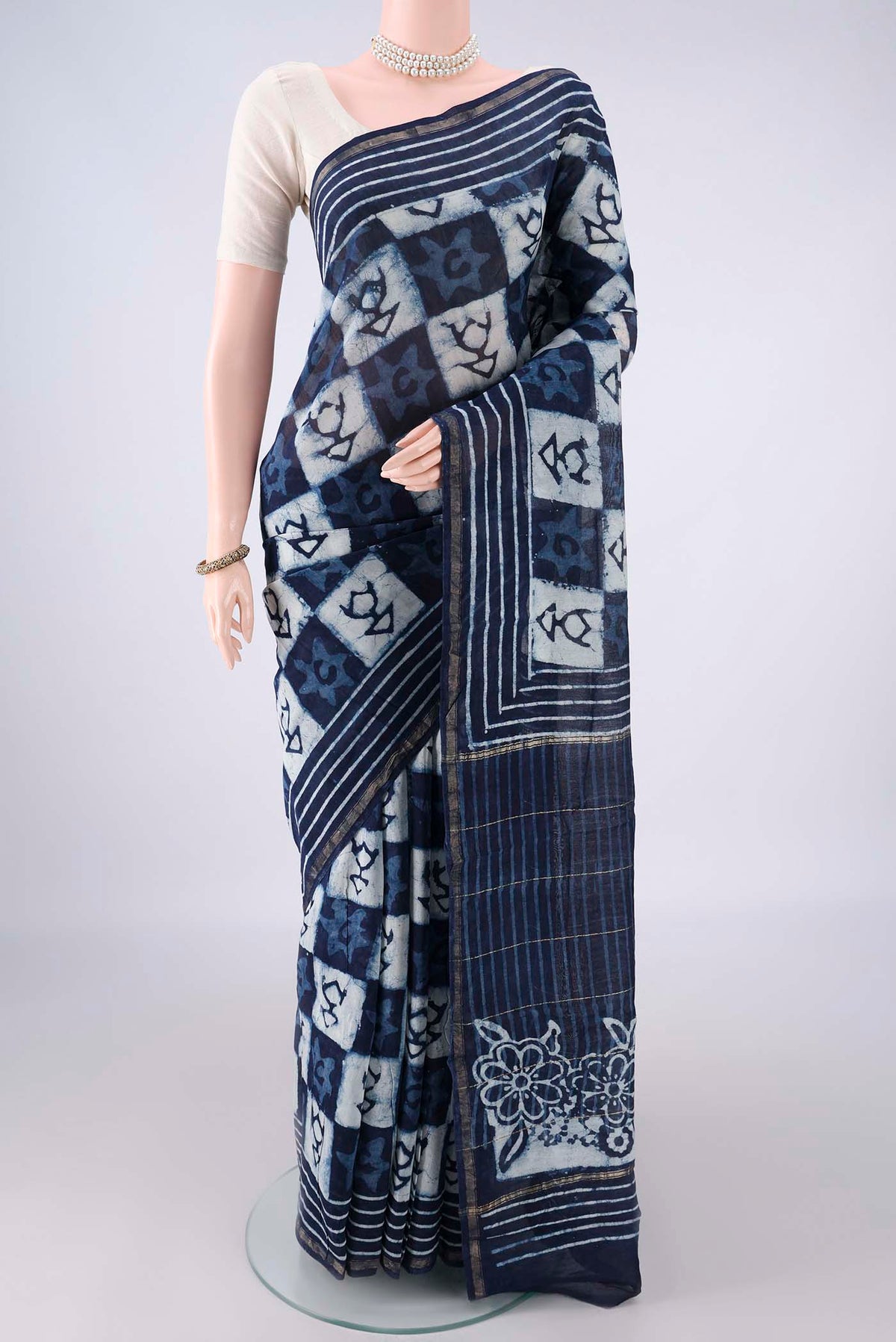 Navy Blue Chanderi Cotton Saree with Batik Print on the body and Thin Zari Line.  displayed on a mannequin