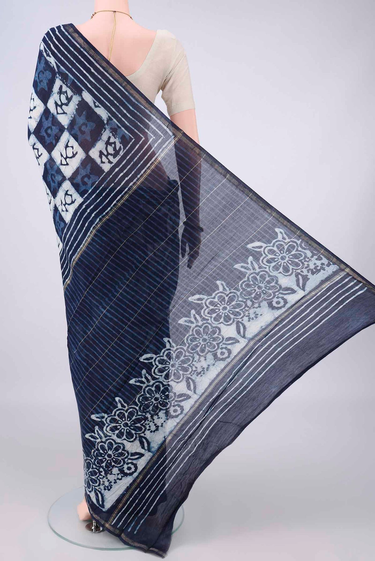 Flat view of Navy Blue Chanderi Cotton Saree with Batik Print on the body and Thin Zari Line. 