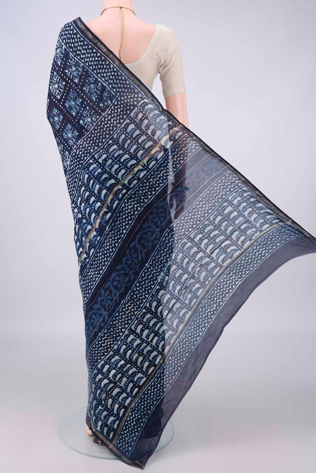 Flat view of Indigo Chanderi Cotton Saree with Batik Print on the body and Thin Zari Line. 