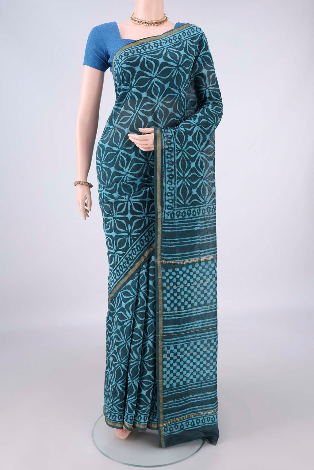 Teal Chanderi Cotton Saree with Batik Print on the body and Thin Zari Line.  displayed on a mannequin
