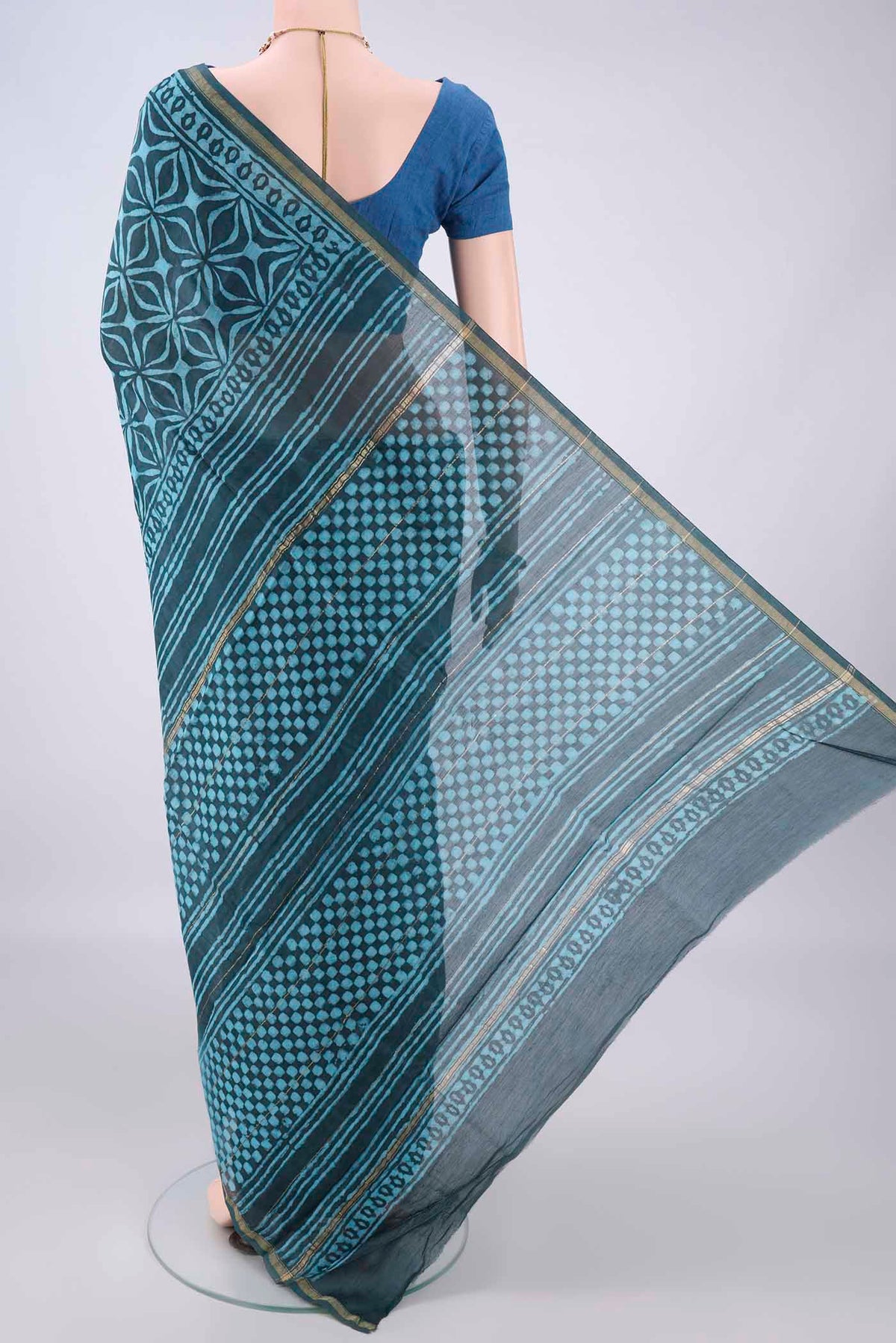 Flat view of Teal Chanderi Cotton Saree with Batik Print on the body and Thin Zari Line. 