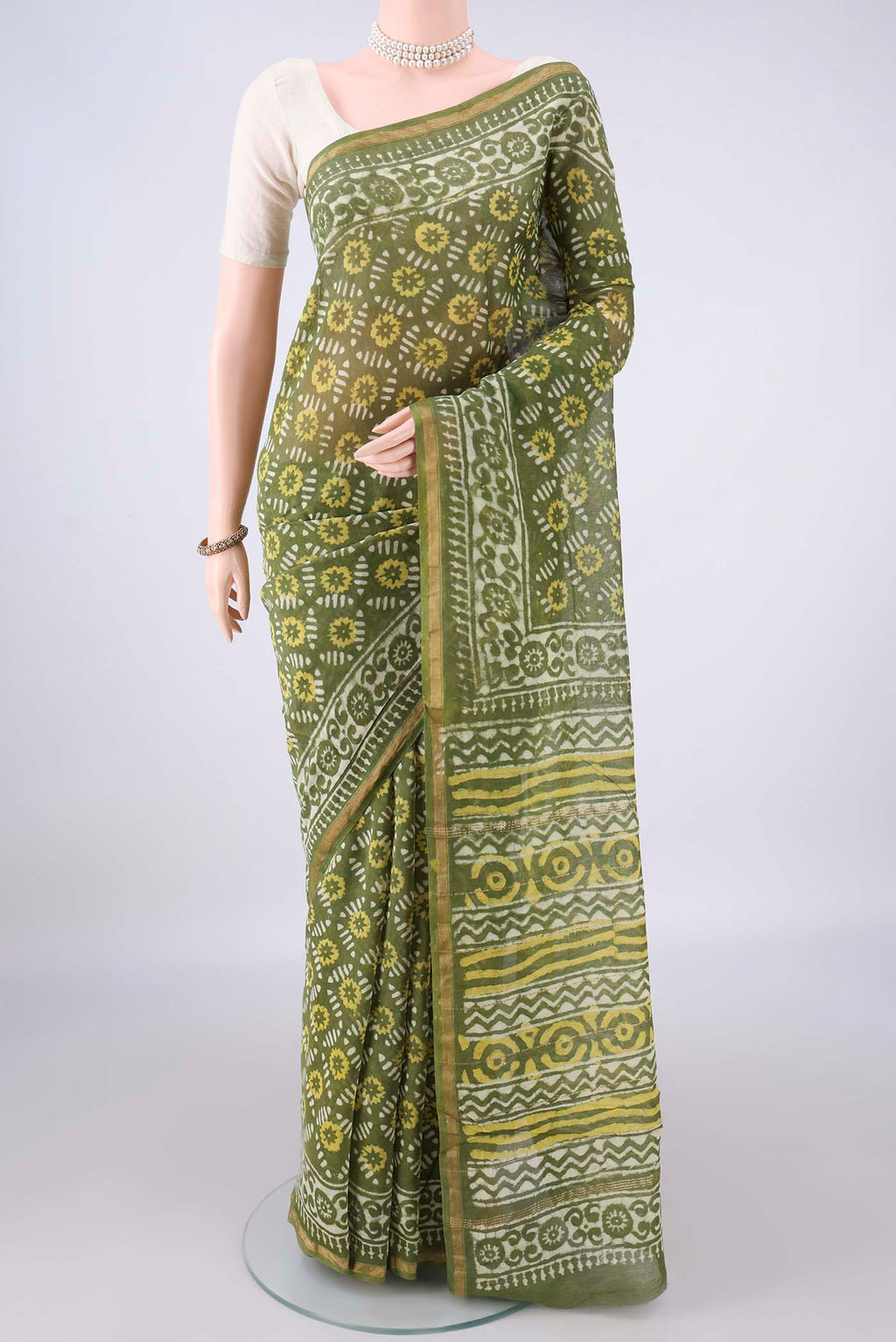 Olive Green Chanderi Cotton Saree with Batik Print on the body and Thin Zari Line.  displayed on a mannequin