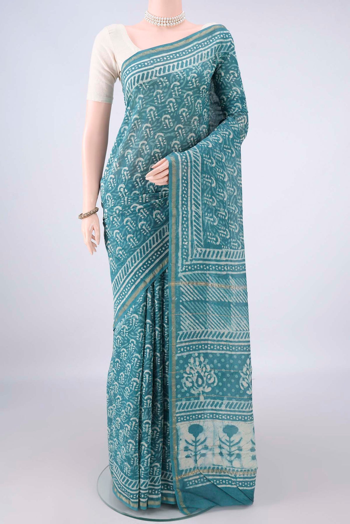Maya Blue Chanderi Cotton Saree with Batik Print on the body and Thin Zari Line.  displayed on a mannequin