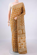 Mustard Chanderi Cotton Saree with Batik Print on the body and Thin Zari Line.  displayed on a mannequin