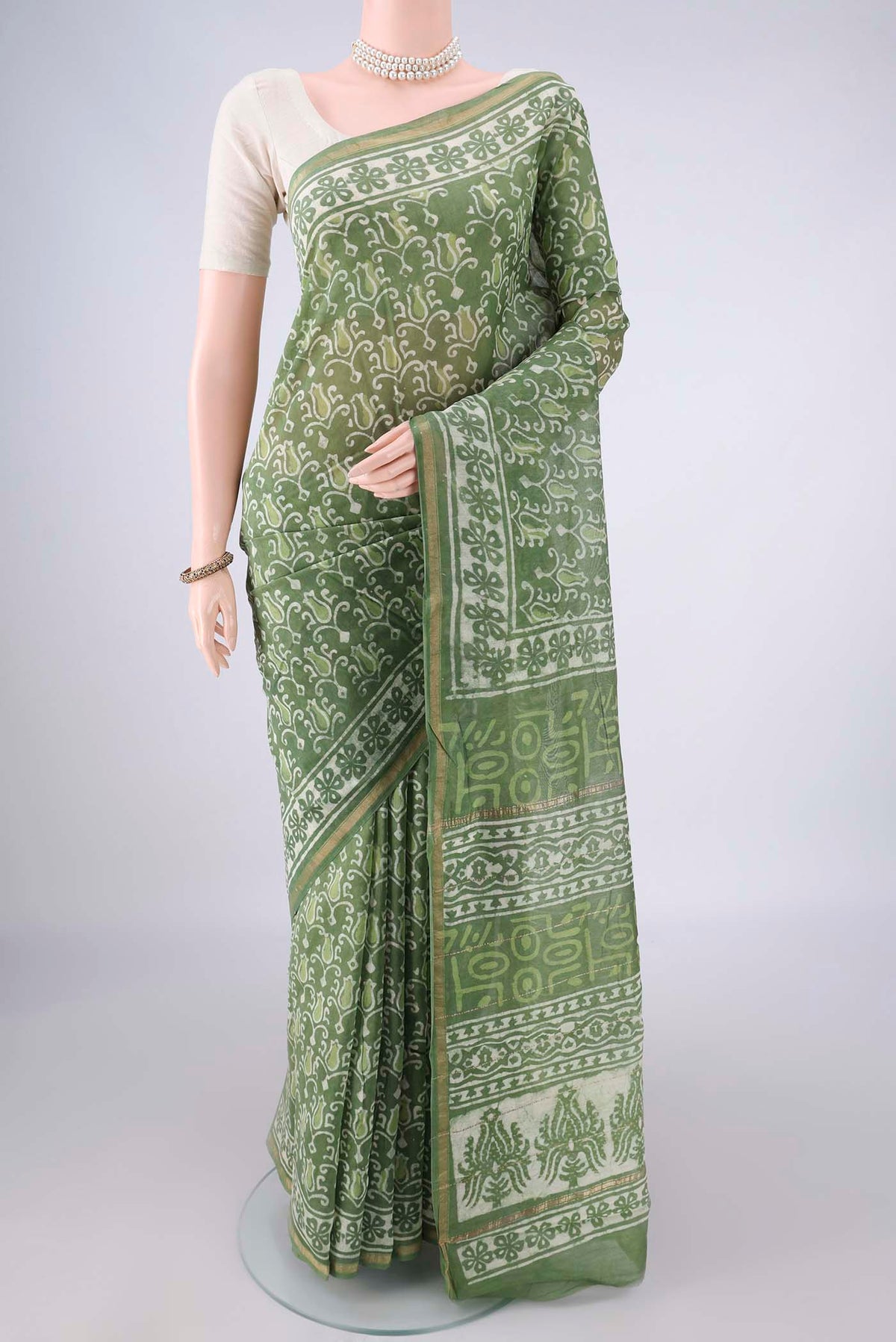 Light Green Chanderi Cotton Saree with Batik Print on the body and Thin Zari Line.  displayed on a mannequin