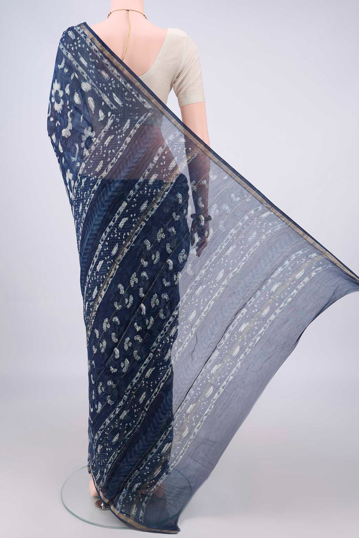 Flat view of Indigo Chanderi Cotton Saree with Batik Print on the body and Thin Zari Line. 