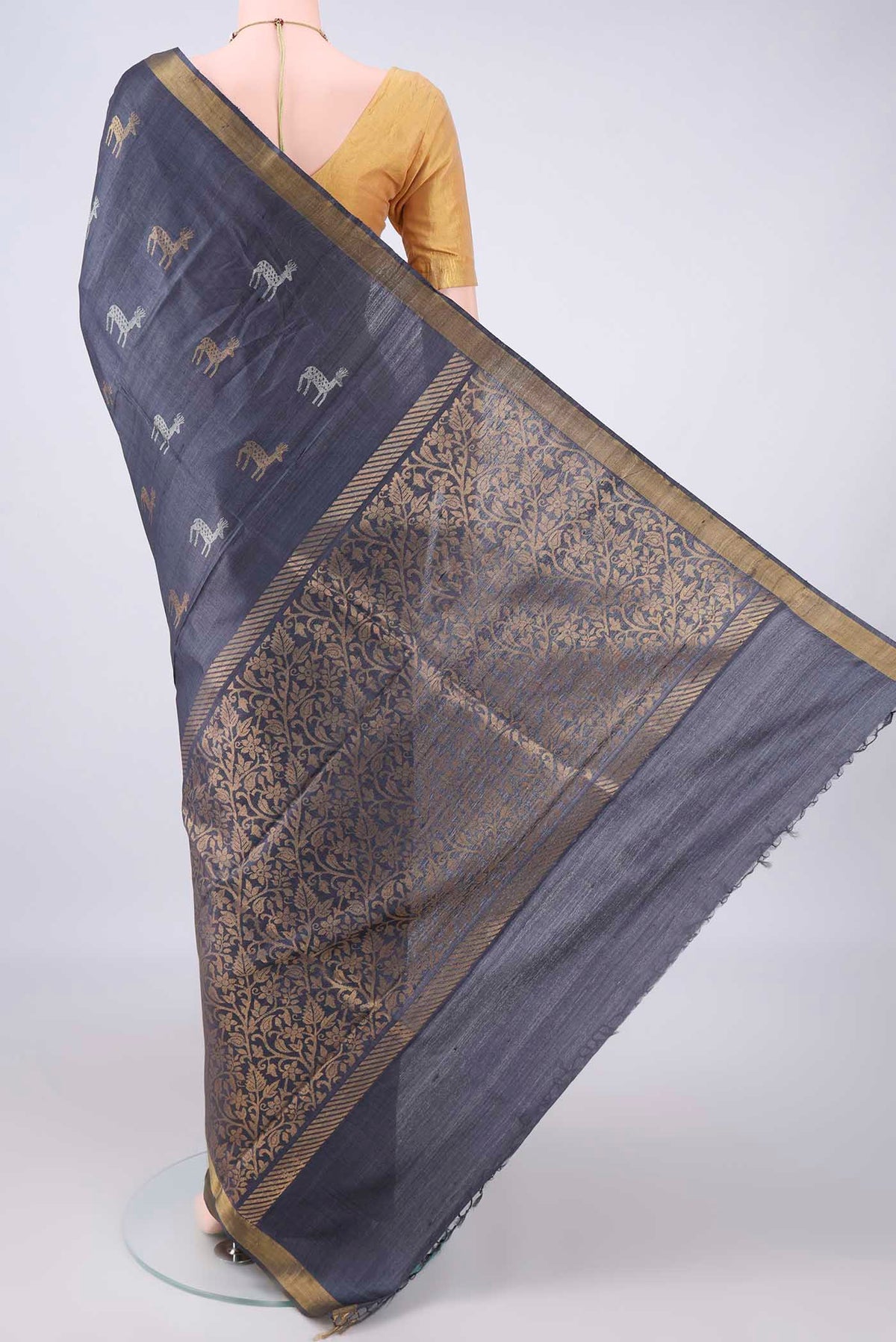 Flat view of Grey MP Tussar Saree with Zari Butta on the body and Zari Border. 